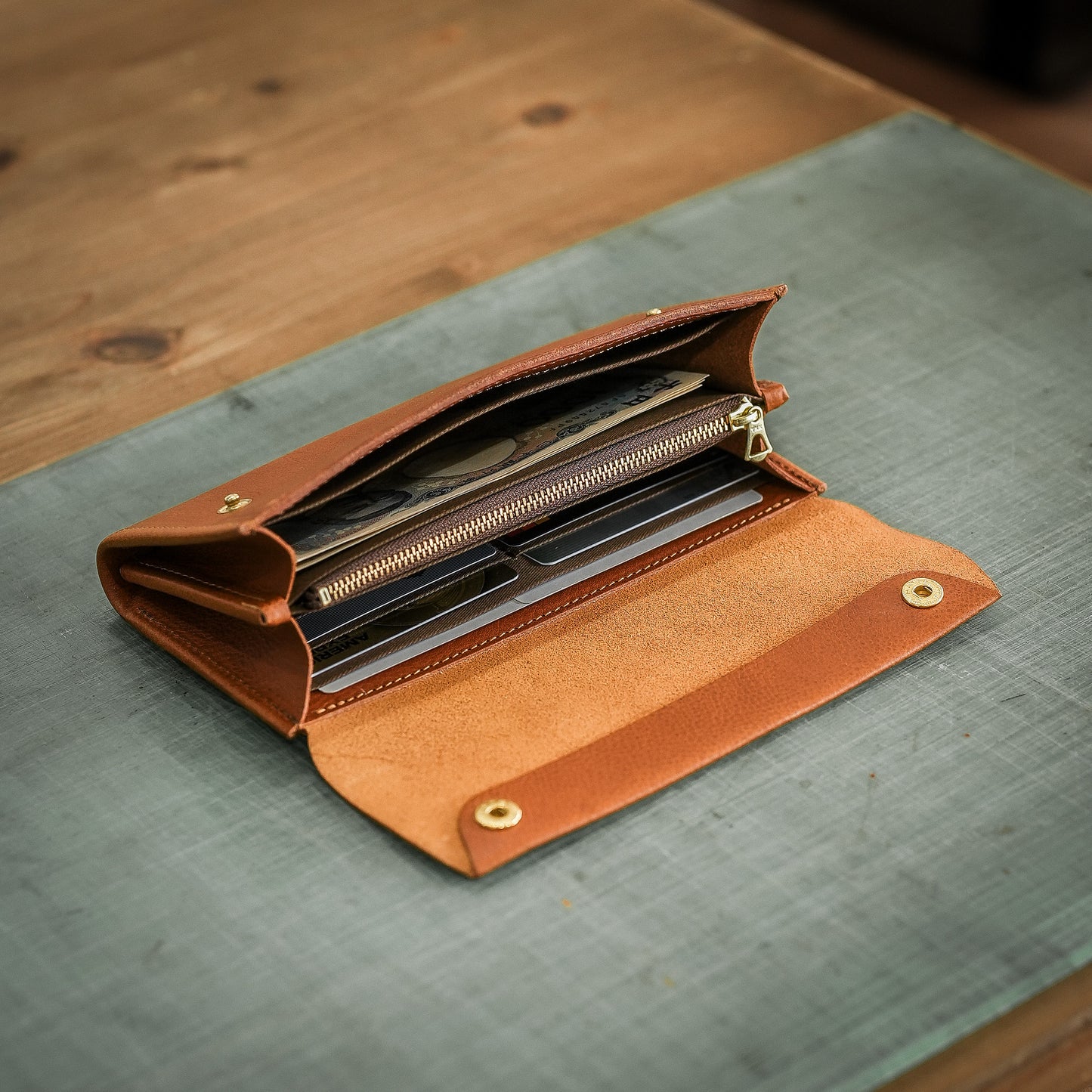 【金具を隠した一枚革】ふっくらと包み込む、くるみホックの長財布。イタリア革 ＜パープル＞