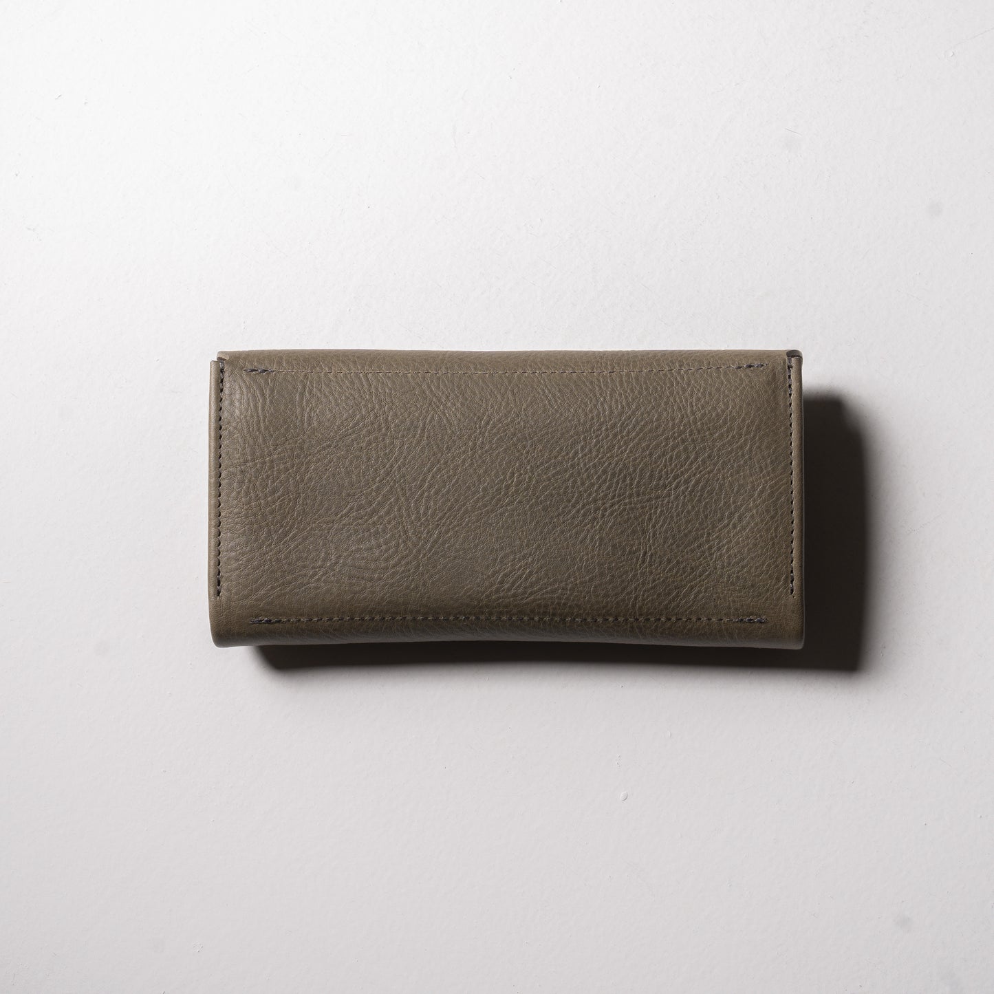 【金具を隠した一枚革】ふっくらと包み込む、くるみホックの長財布。イタリア革 ＜グリージオ＞