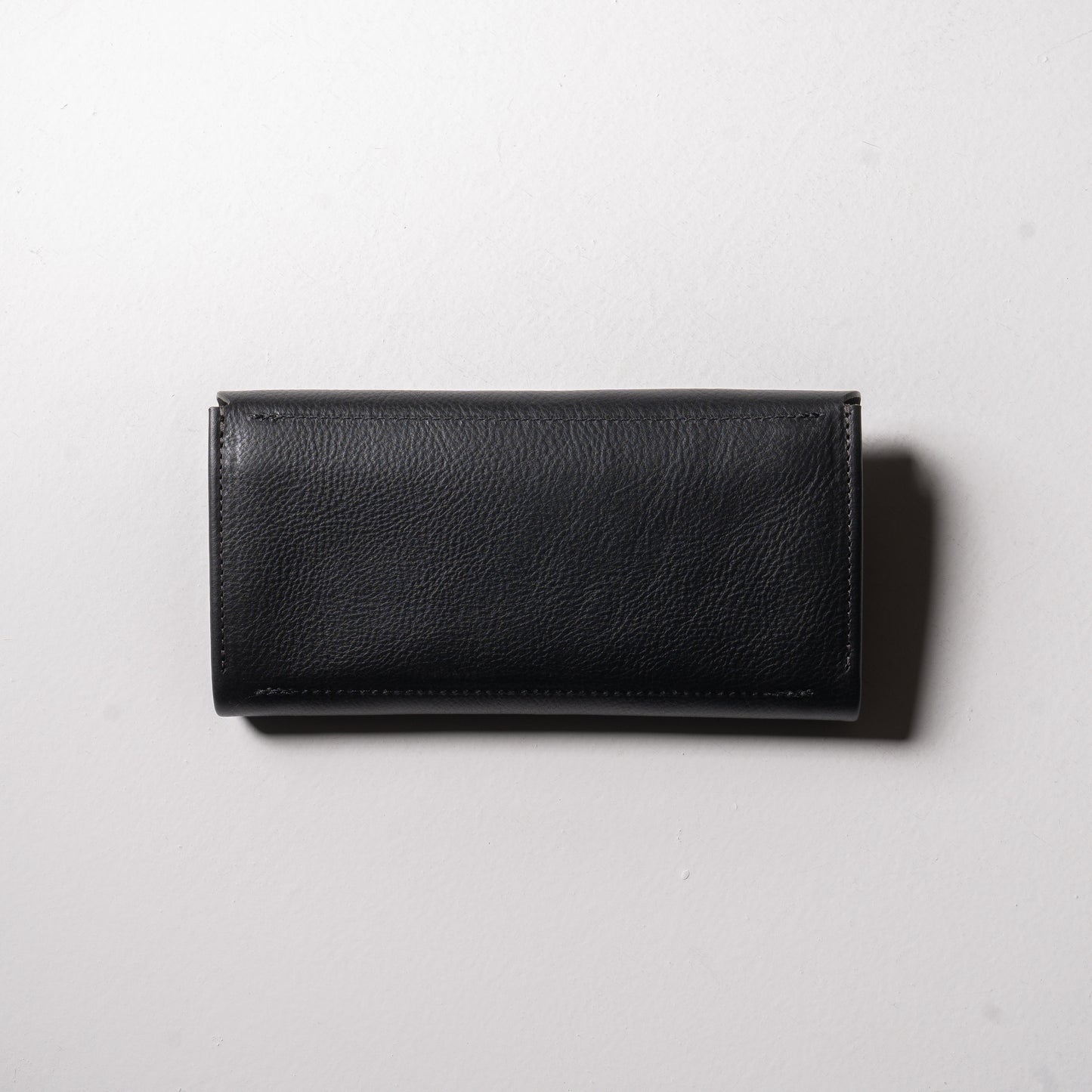 【金具を隠した一枚革】ふっくらと包み込む、くるみホックの長財布。イタリア革 ＜ブラック＞