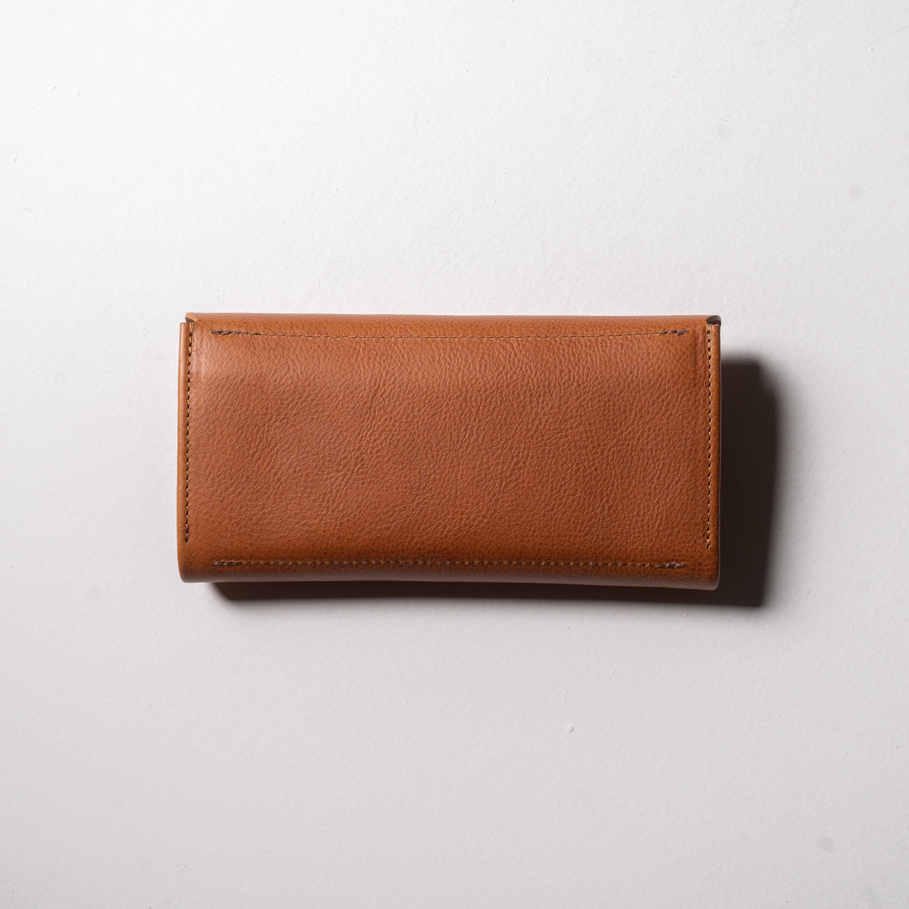 金具を隠した一枚革】ふっくらと包み込む、くるみホックの長財布