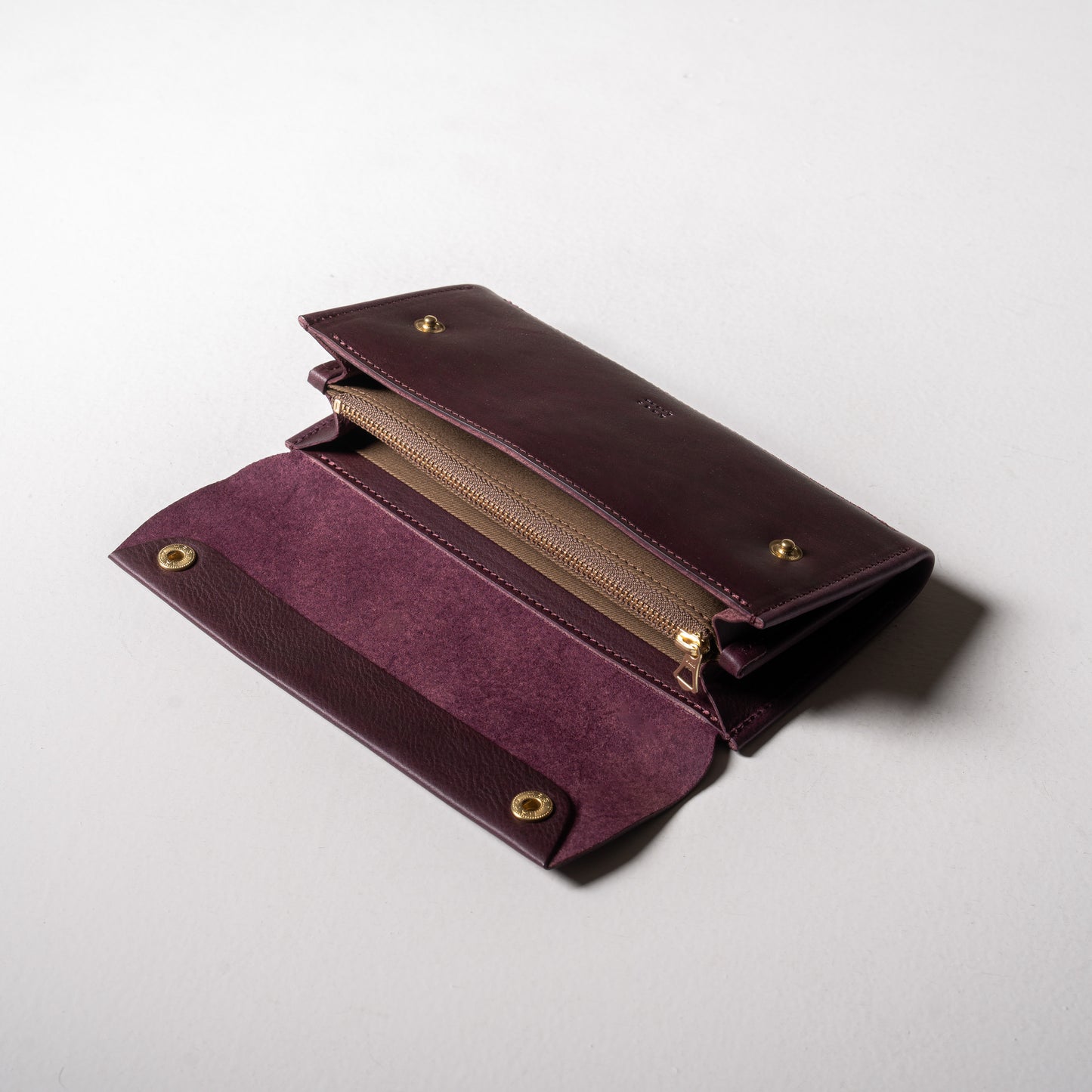 【金具を隠した一枚革】ふっくらと包み込む、くるみホックの長財布。イタリア革 ＜パープル＞